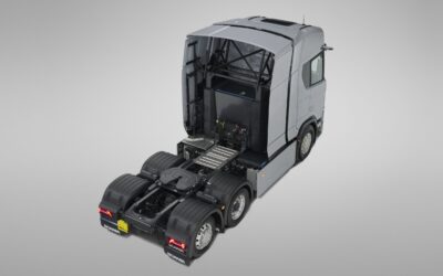 Studioaufnahme einer batterieelektrischen Dreiachs-Sattelzugmaschine von Scania mit zusätzlichen Batteriepaketen hinter der Kabinenrückwand; Ansicht von schräg hinten