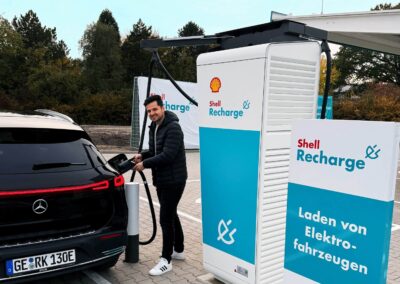 Ein Mann lädt an einer Ladestation von Shell Recharge seinen Elektro-Pkw