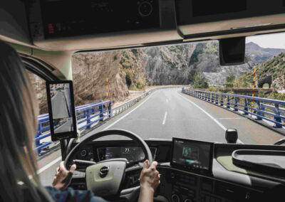 Innenansicht eines Volvo-Lkw mit Fahrerin, Blick durch die Windschutzscheibe auf die Straße