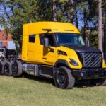 Schwerlastzugmaschine vom Typ Volvo VNX 640 mit vier Achsen, US-amerikanischer Hauber mit knapp 1,60 Meter langem Schlafabteil, geparkt auf einer Wiese