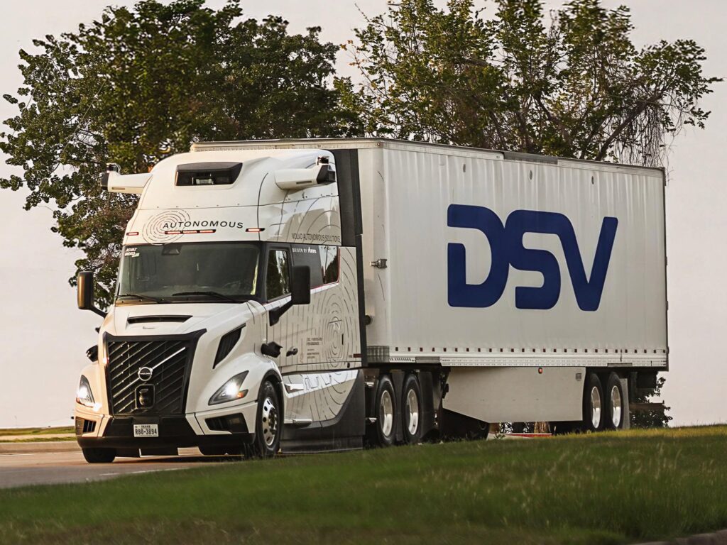 Ein autonom fahrender Sattelzug von Volvo Autonomous Solutions auf einer Straße, auf dem Sattelauflieger der Schriftzug von Logistiker DSV