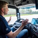 Ein Werksfahrer von ZF nimmt in einem fahrenden Versuchs-Lkw gut sichtbar die Hände vom Lenkrad, um ein hohes Maß an Automatisierung zu demonstrieren